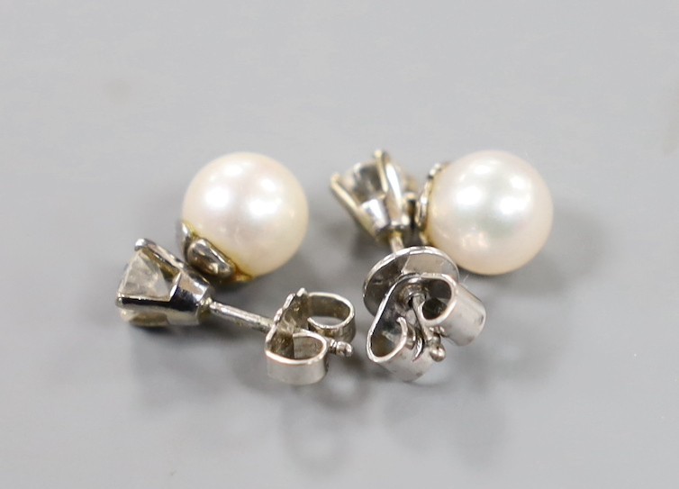 A pair of white metal cultured pearl and single stone diamond set ear studs (butterflies differ) pearl diameter 6.8mm, gross weight 2.7 grams.